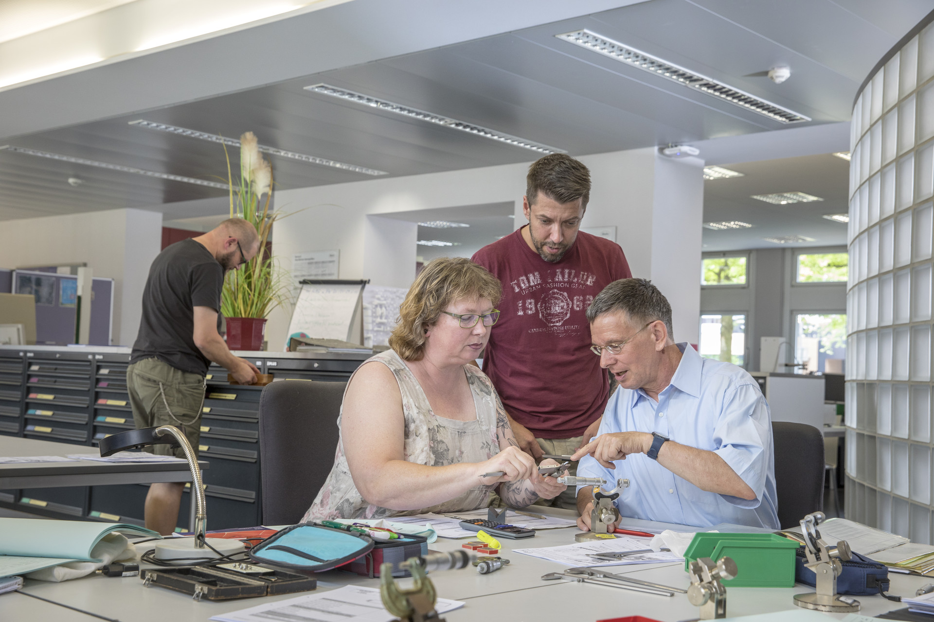 Teilnehmer mit Dozent bei technischer Ausbildung Ein Dozent erklärt Teilnehmenden etwas.