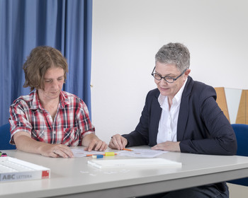 Logopädie Szene aus der logopädischen Sprechstunde: Zwei Frauen im Gespräch