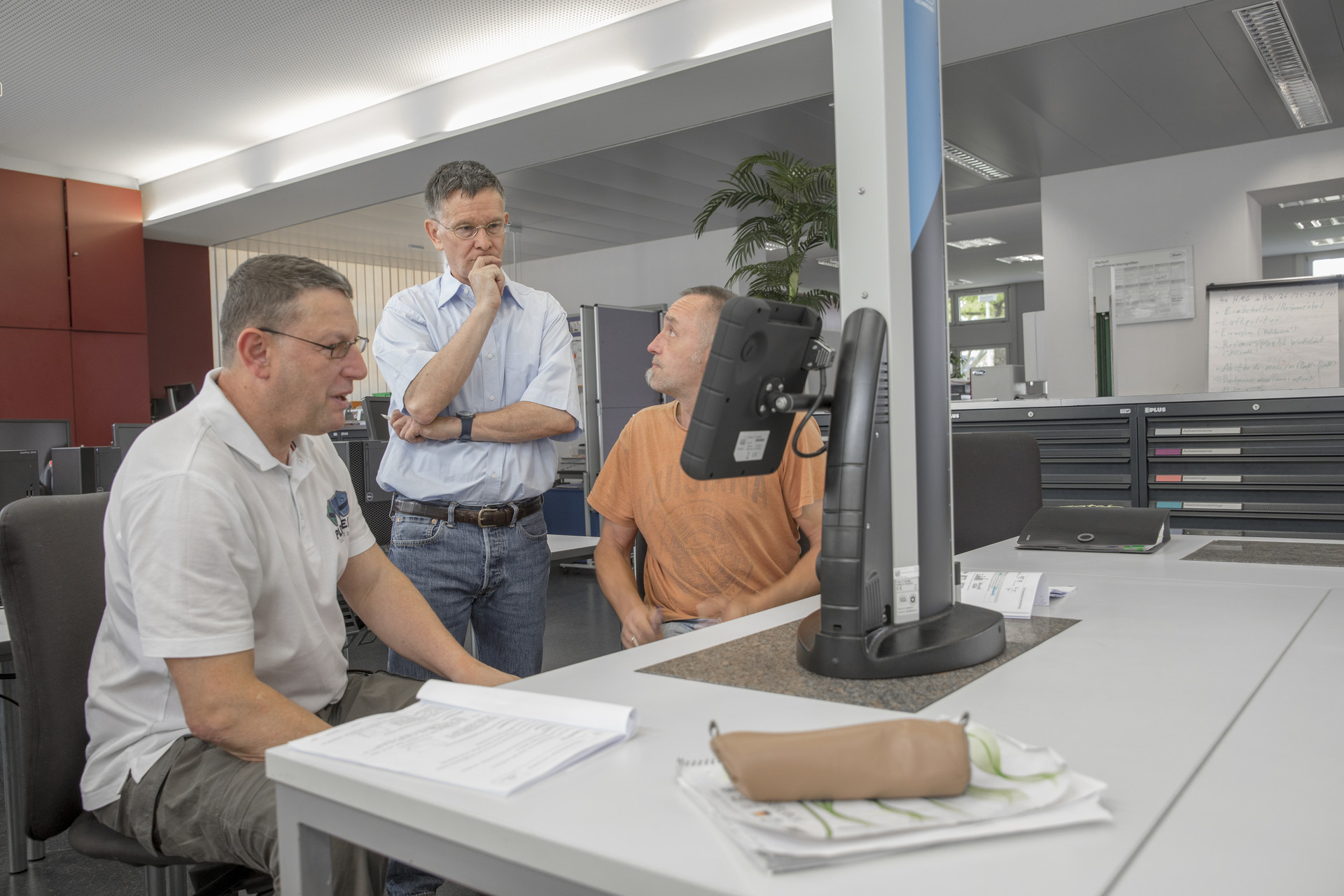 Blick in die technische Werkstatt mit Dozent und Teilnehmern Werkstatt mit Teilnehmenden und einem Dozenten