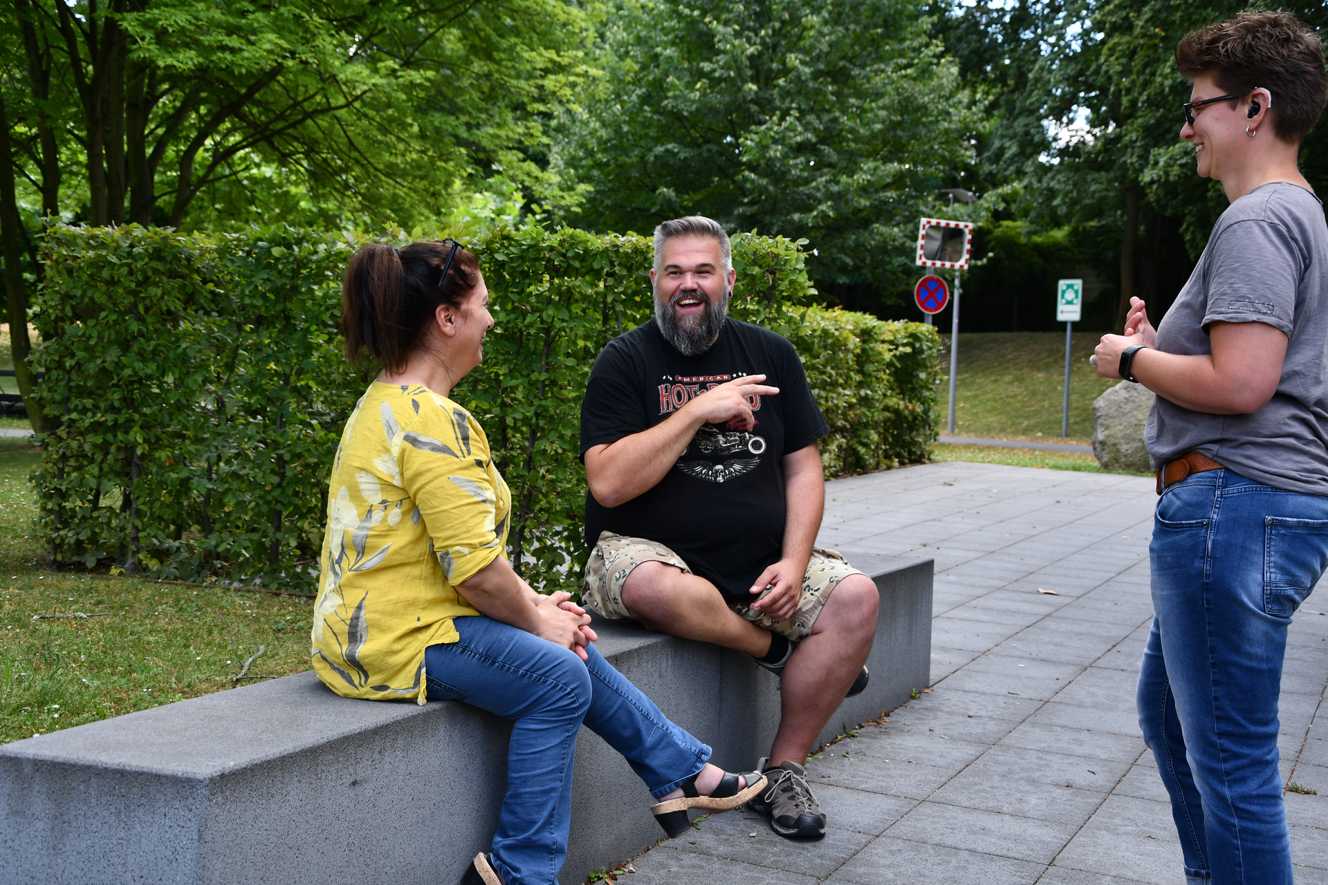 Teilnehmende kommunizieren miteinander auf einer Bank