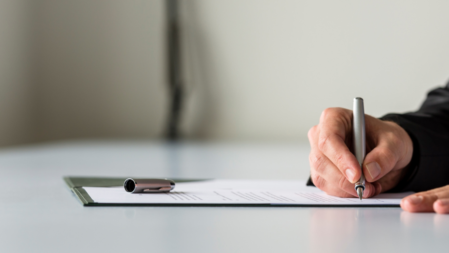 Teilnehmender unterschreibt Zeugnis