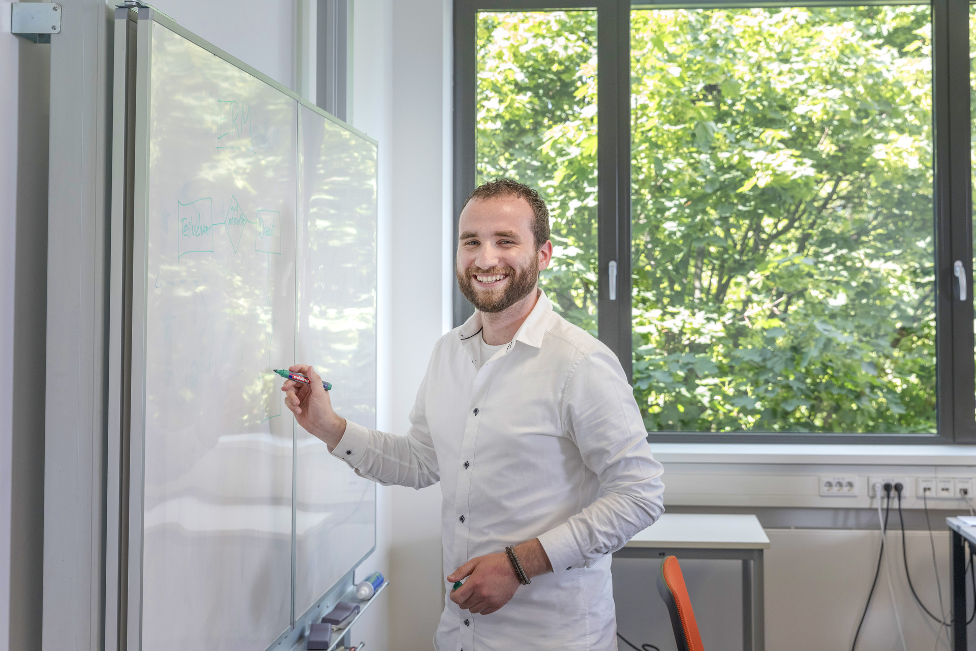 Mitarbeiter schreibt Notizen an Tafel an