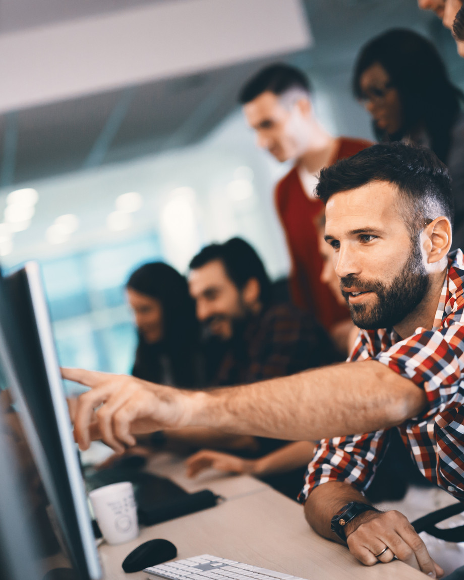 Teilnehmende zeigen auf den Bildschirm eines PCs