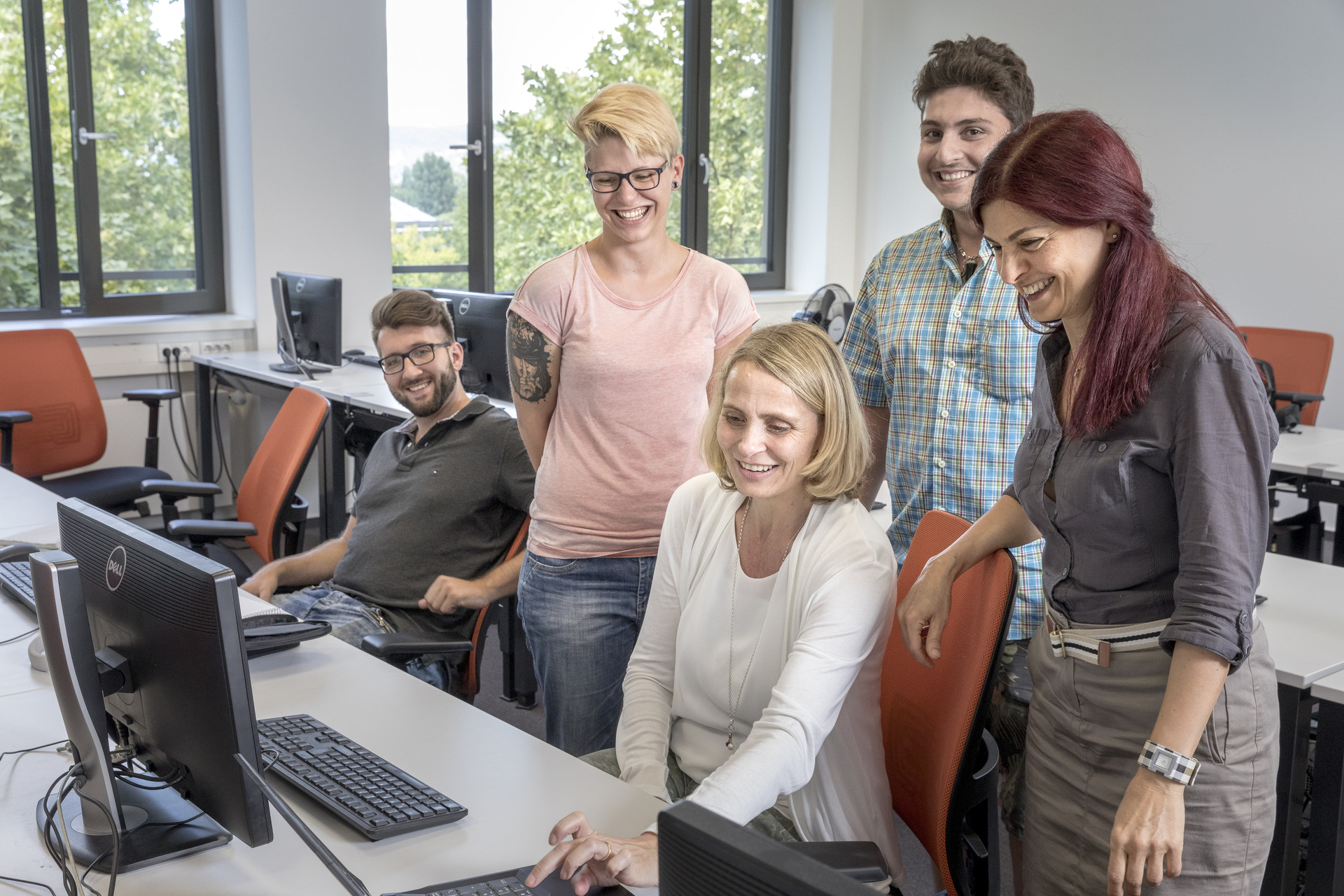 Gruppenarbeit in der Klasse Teilnehmerin erklärt etwas an ihrem Bildschirm