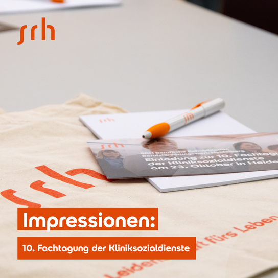 Ein Tisch mit Informationsmaterialien und einem Stift, darunter Broschüren und ein Beutel mit dem Text "SRH"
