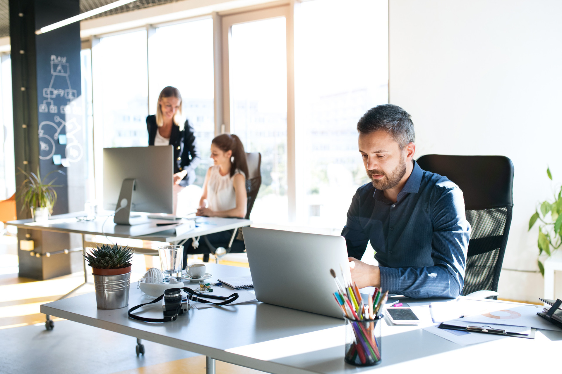 Büro: Drei Personen arbeiten an Rechnern