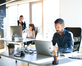 Büro: Drei Personen arbeiten an Rechnern