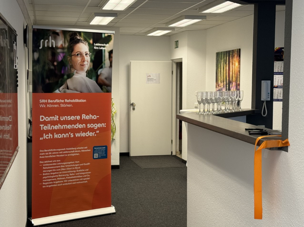 Ein Raum mit Rollup-Bannern und einem Tisch mit Gläsern.