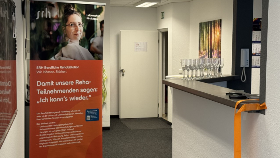 Ein Raum mit Rollup-Bannern und einem Tisch mit Gläsern.