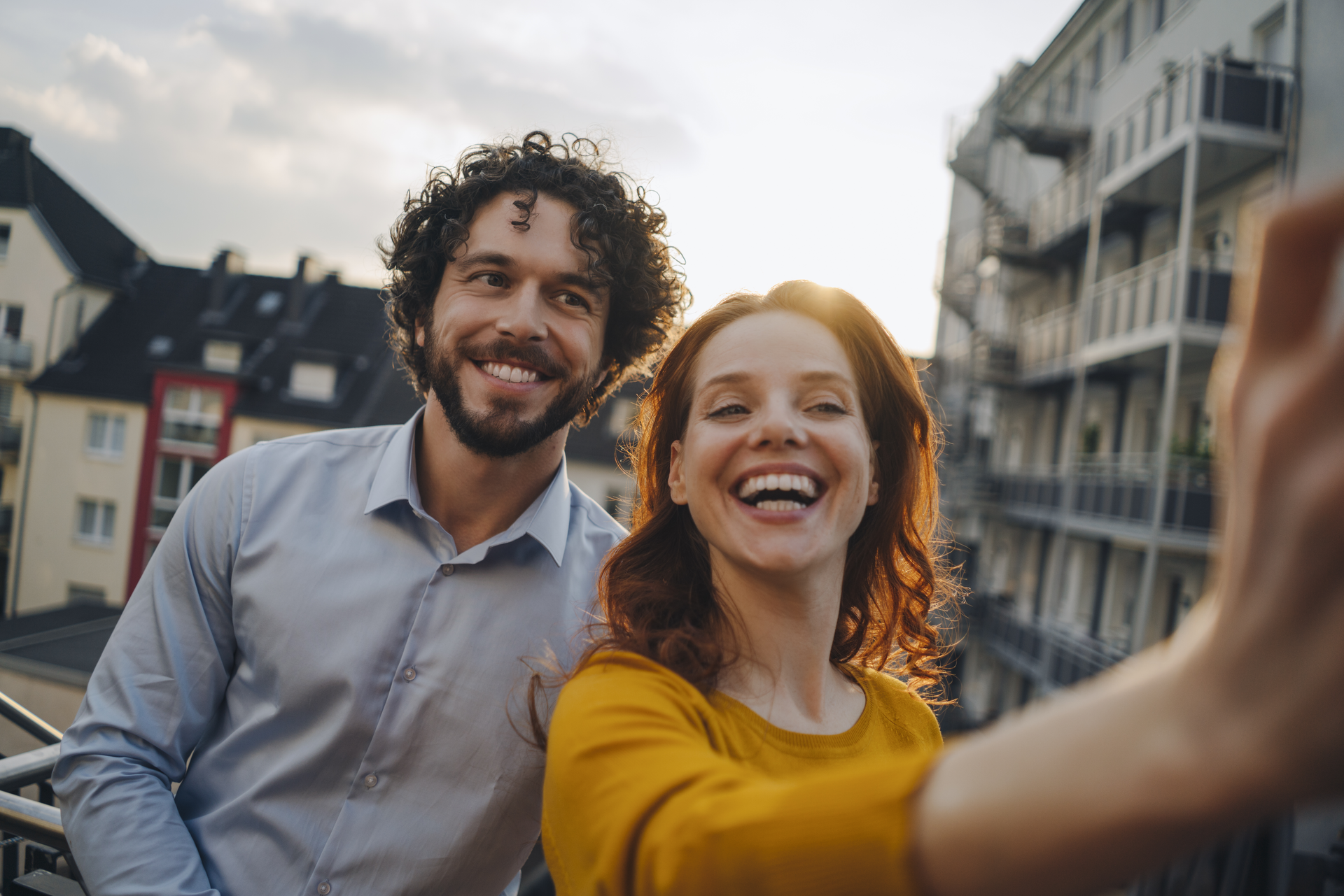 Frau und Mann schießen draußen ein Selfie von sich und lächeln