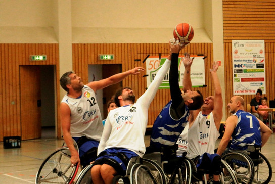 Foto: Rollstuhl-Basketballer versuchen, einen Spieler am Wurf Richtung Korb zu hindern