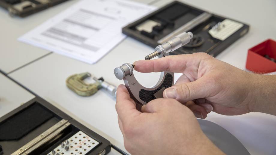 Hände halten Messgerät für die Qualitätsprüfung