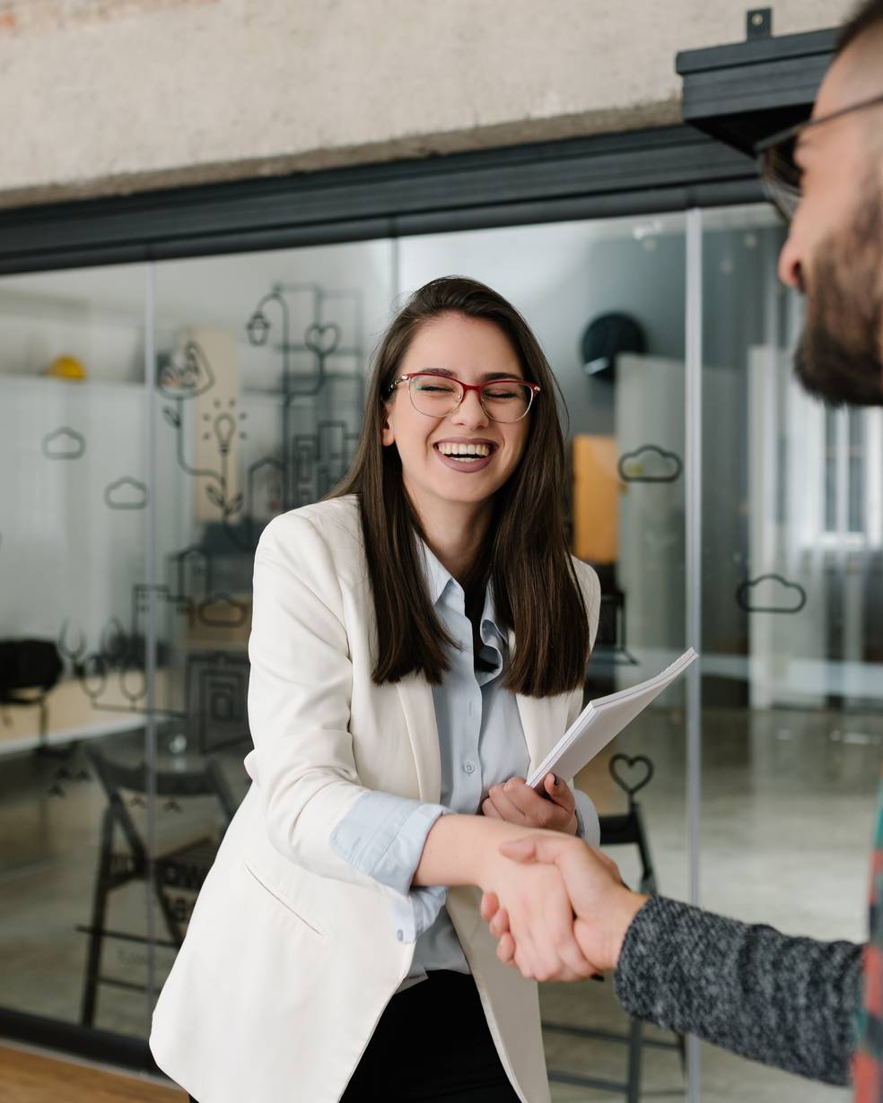 Zwei Personen schütteln sich die Hände in einem Büro