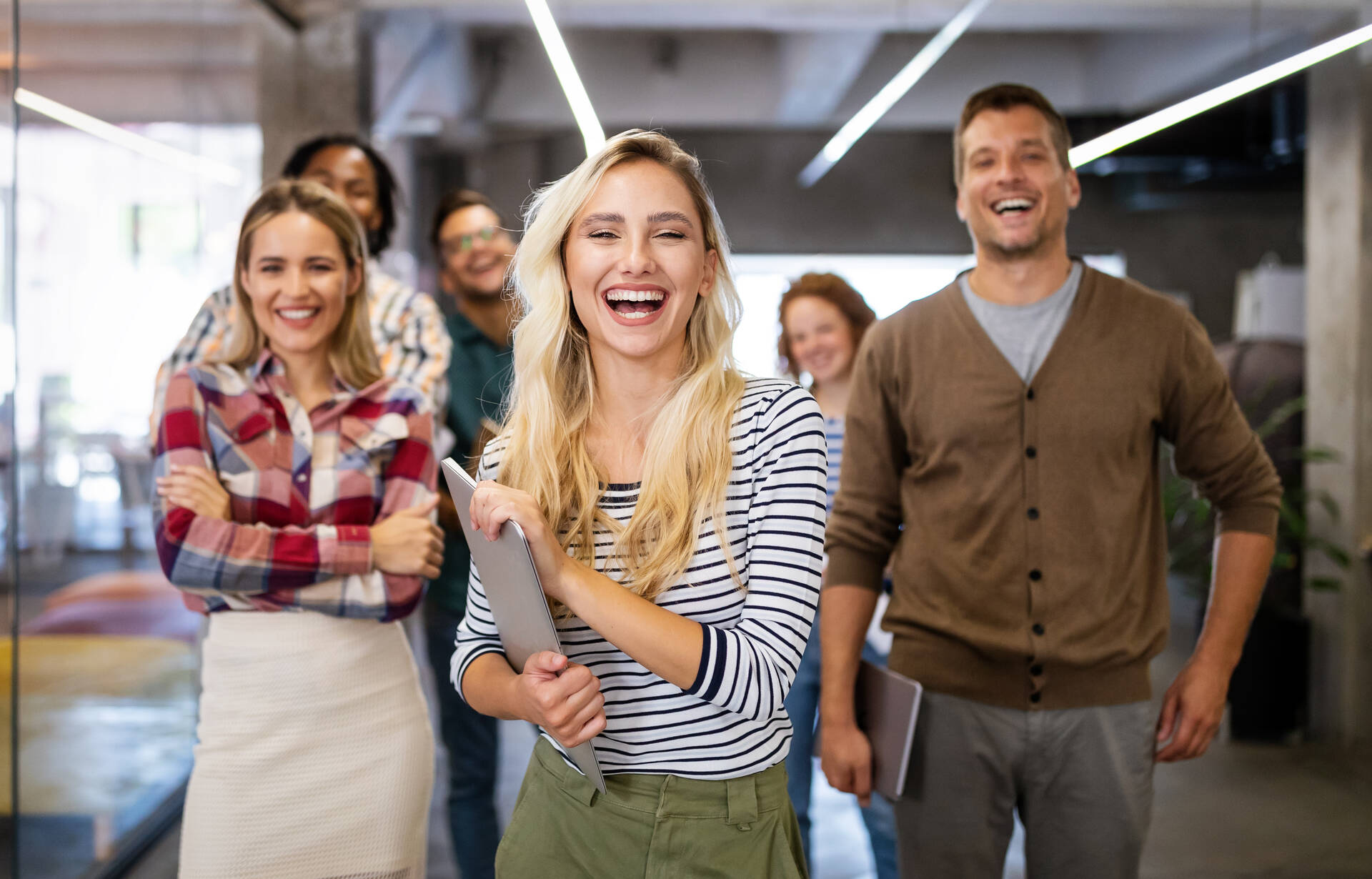 Eine Gruppe von Menschen lacht in einem Büro