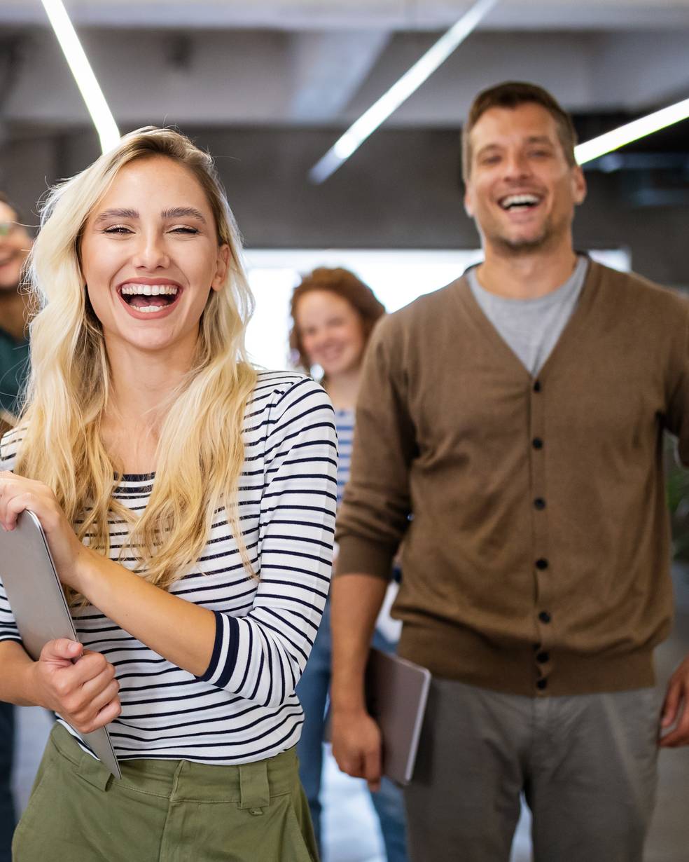 Eine Gruppe von Menschen lacht in einem Büro
